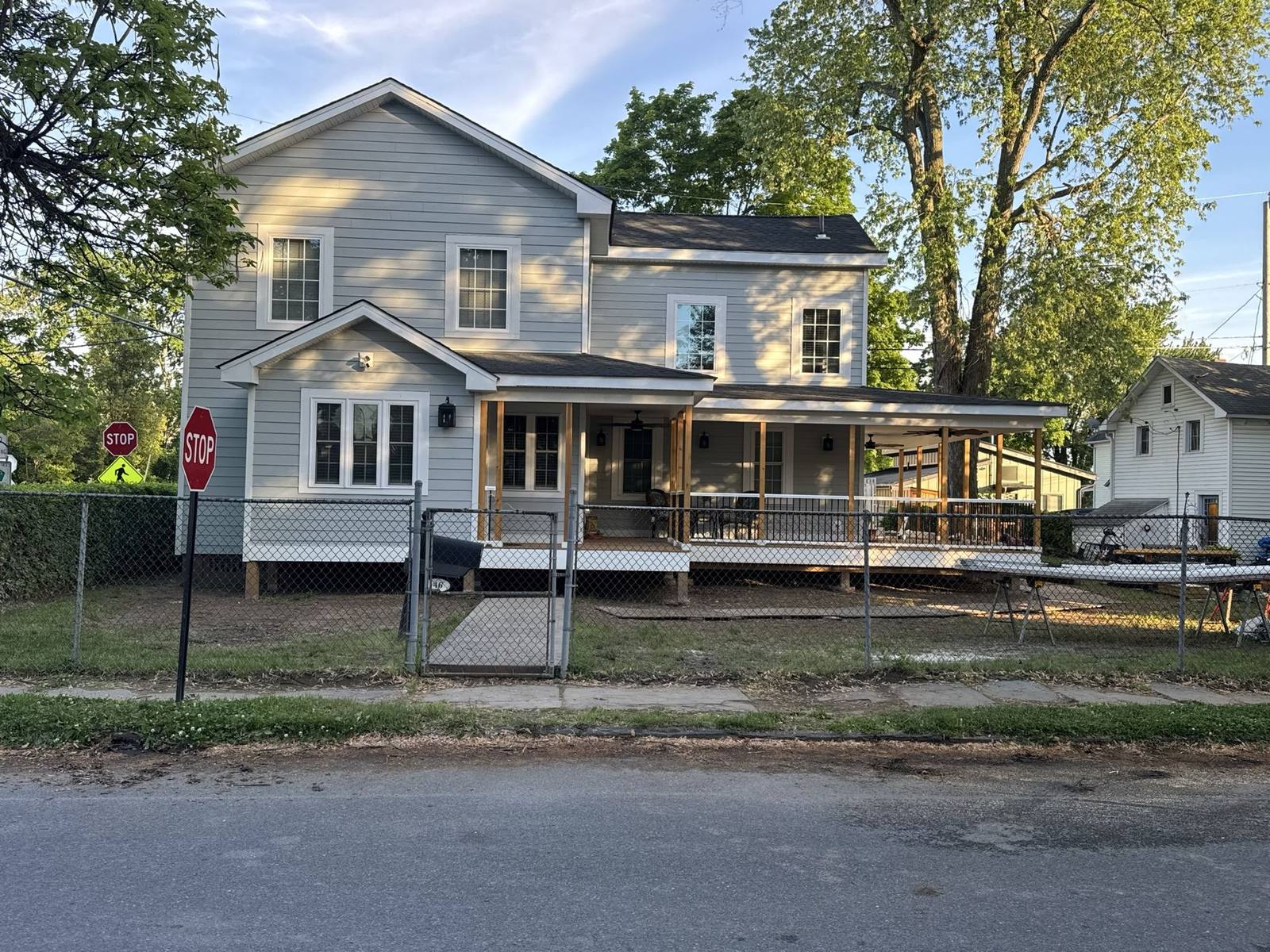 Two-story home mid-renovation with new siding and porch framing